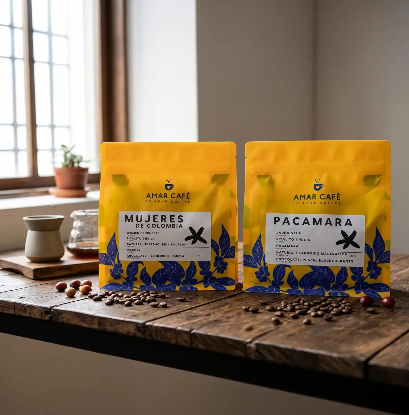 Bolsas de Amar Café Mujeres de Colombia y Pacamara sobre una mesa de madera junto a una ventana
